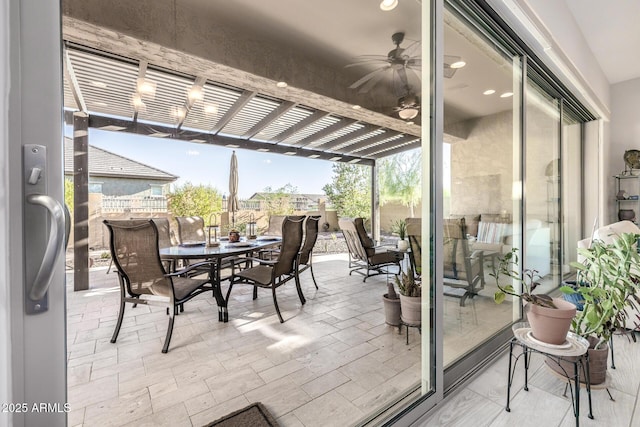 sunroom / solarium with outdoor dining space and a ceiling fan