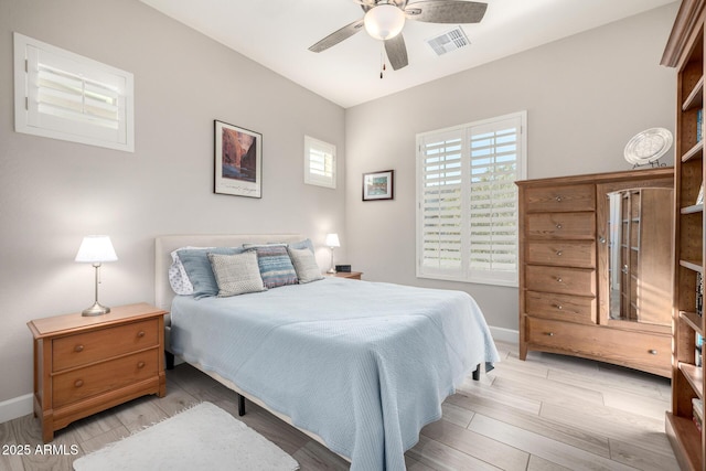bedroom with light wood-style floors, baseboards, and a ceiling fan