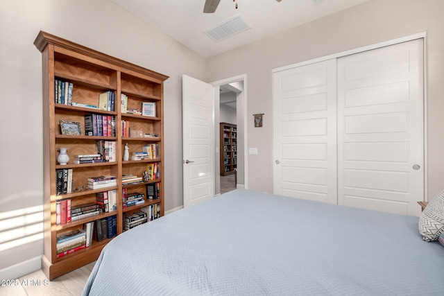 bedroom featuring a closet, light wood-type flooring, baseboards, and a ceiling fan