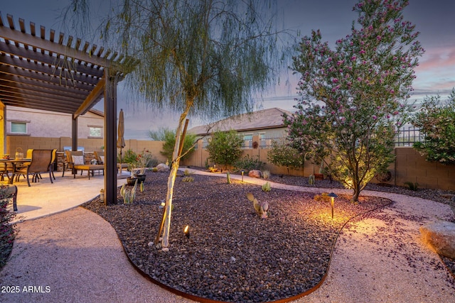 yard at dusk with a pergola, a fenced backyard, and a patio area