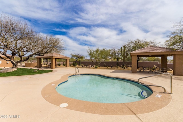 community pool with a gazebo and a patio area