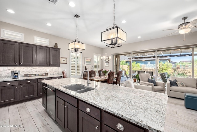 kitchen with a sink, open floor plan, dark brown cabinetry, dishwasher, and backsplash