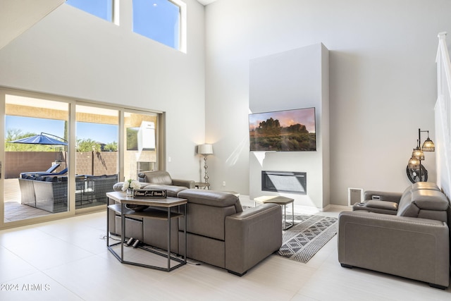 tiled living room featuring a healthy amount of sunlight and a towering ceiling