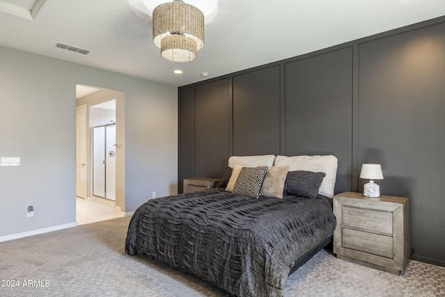 bedroom featuring light carpet, an inviting chandelier, and ensuite bathroom