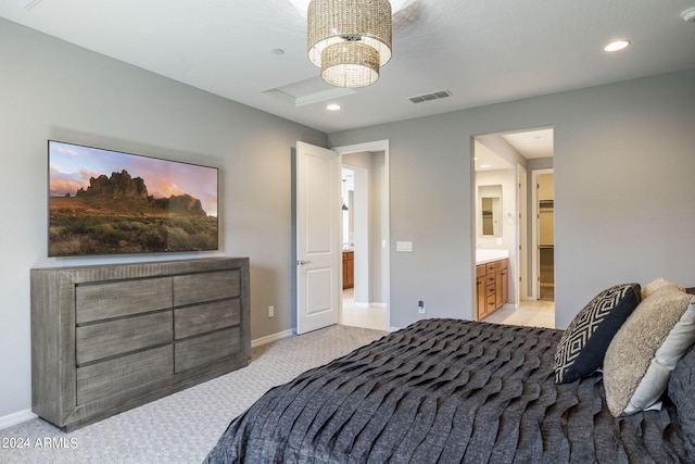 carpeted bedroom with ensuite bathroom and an inviting chandelier