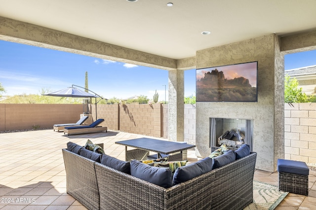 view of patio with an outdoor living space with a fireplace