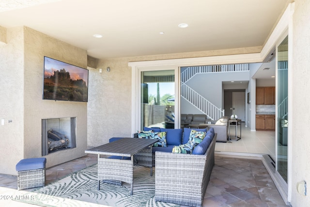 view of patio with an outdoor living space with a fireplace