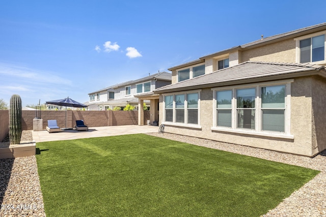 back of property featuring a patio area and a lawn