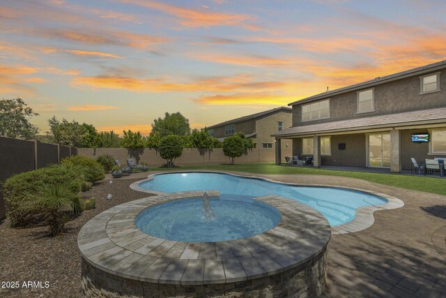 11875 W Lone Tree Trl, Peoria, AZ 85383 - pool at dusk with a fenced backyard, a patio area, and a pool with connected hot tub