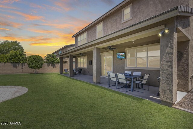 11875 W Lone Tree Trl, Peoria, AZ 85383 - back of house at dusk featuring ceiling fan, stucco siding, and a patio