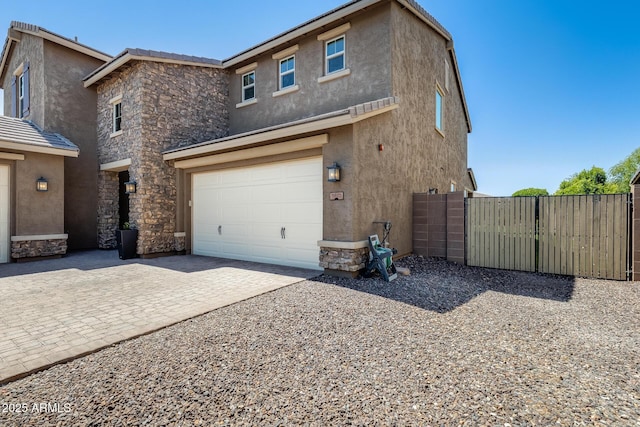 11875 W Lone Tree Trl, Peoria, AZ 85383 - view of front of property with stone siding, an attached garage, stucco siding, and driveway