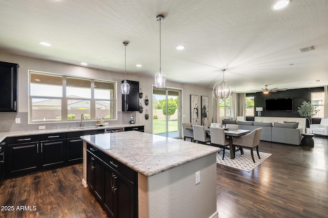 11875 W Lone Tree Trl, Peoria, AZ 85383 - kitchen with dark cabinets, a sink, dark wood finished floors, a center island, and tasteful backsplash