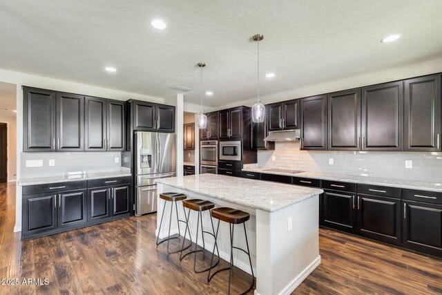 11875 W Lone Tree Trl, Peoria, AZ 85383 - kitchen featuring appliances with stainless steel finishes, under cabinet range hood, a center island, tasteful backsplash, and recessed lighting