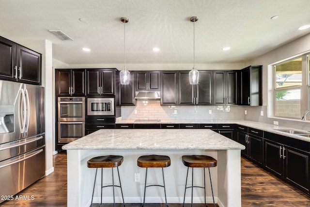 11875 W Lone Tree Trl, Peoria, AZ 85383 - kitchen featuring stainless steel appliances, a sink, a center island, a kitchen breakfast bar, and under cabinet range hood