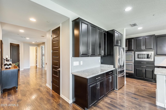 11875 W Lone Tree Trl, Peoria, AZ 85383 - kitchen featuring appliances with stainless steel finishes, decorative backsplash, dark wood-style floors, light stone counters, and recessed lighting