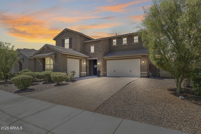 11875 W Lone Tree Trl, Peoria, AZ 85383 - traditional home featuring stone siding, decorative driveway, stucco siding, and an attached garage