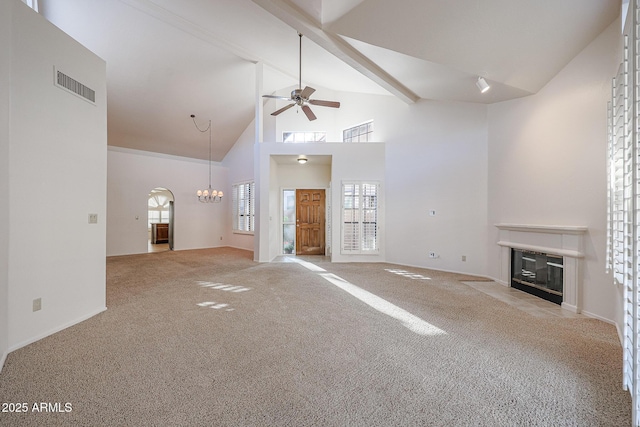 unfurnished living room featuring high vaulted ceiling, ceiling fan with notable chandelier, light colored carpet, and beamed ceiling