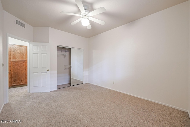 unfurnished bedroom with light colored carpet, ceiling fan, and a closet