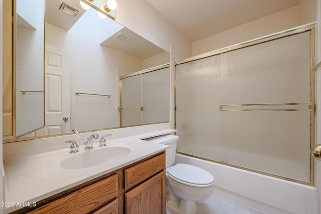 full bathroom featuring vanity, tile patterned flooring, bath / shower combo with glass door, and toilet