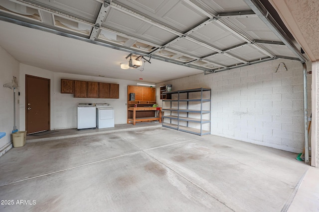 garage with a garage door opener and washing machine and clothes dryer