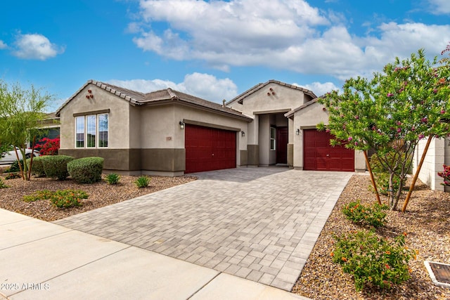 ranch-style home with a garage, stucco siding, driveway, and a tiled roof