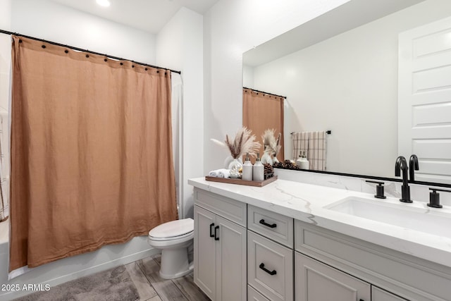 bathroom with vanity, shower / bathtub combination with curtain, toilet, and wood finished floors