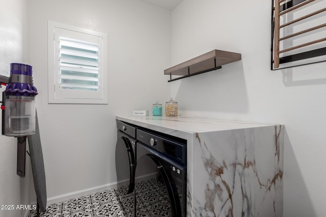 washroom with laundry area, washer and clothes dryer, and baseboards