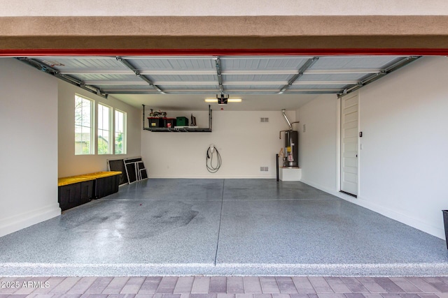 garage featuring baseboards, a garage door opener, and water heater