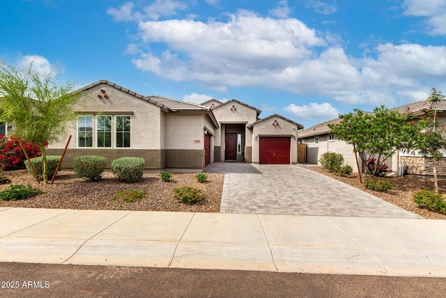 view of front facade with an attached garage, stucco siding, driveway, and a tiled roof