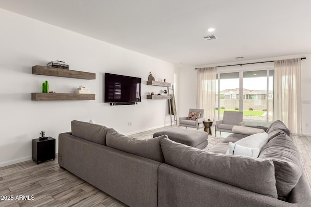 living room with baseboards, wood finished floors, and visible vents