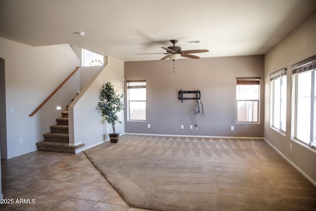 interior space with a healthy amount of sunlight, light colored carpet, and ceiling fan