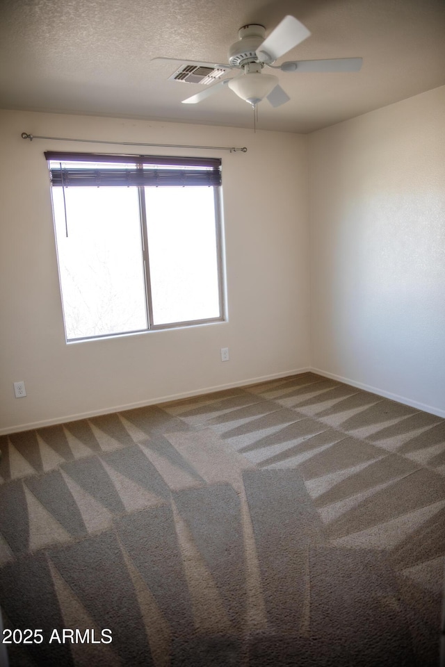 empty room featuring ceiling fan, carpet floors, and a textured ceiling