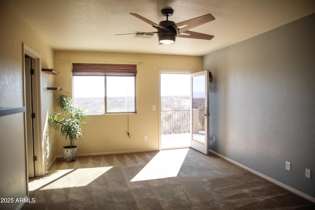 carpeted spare room featuring ceiling fan