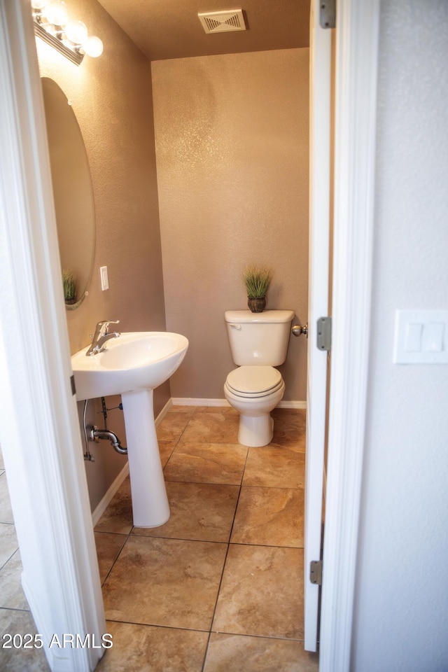 bathroom featuring toilet and tile patterned flooring