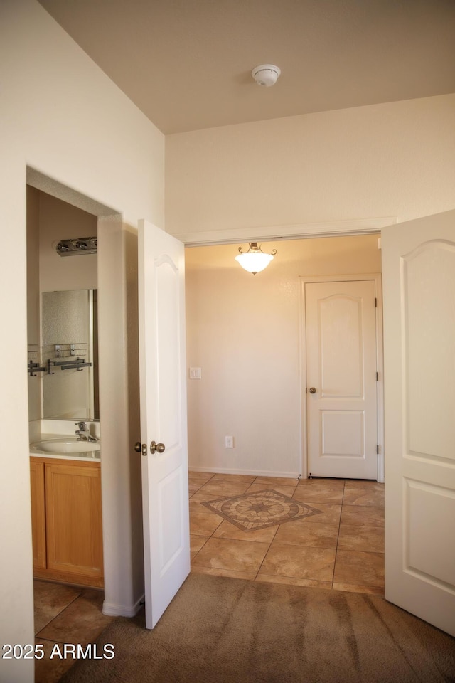 hall with sink and tile patterned floors