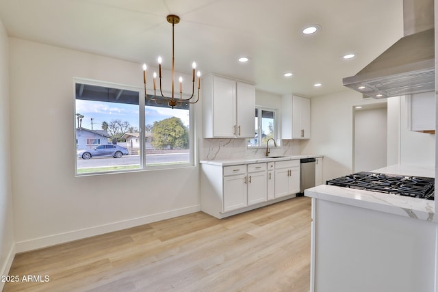 kitchen featuring appliances with stainless steel finishes, white cabinetry, sink, island exhaust hood, and light wood-type flooring