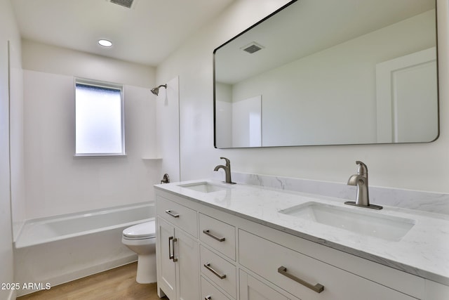 full bathroom featuring hardwood / wood-style flooring, vanity, toilet, and shower / washtub combination