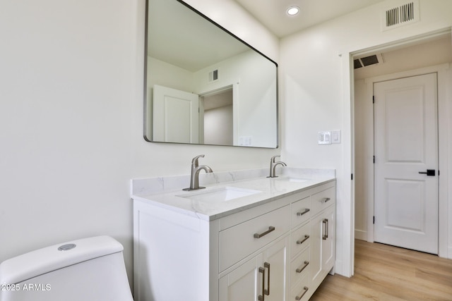 bathroom with vanity, toilet, and hardwood / wood-style floors