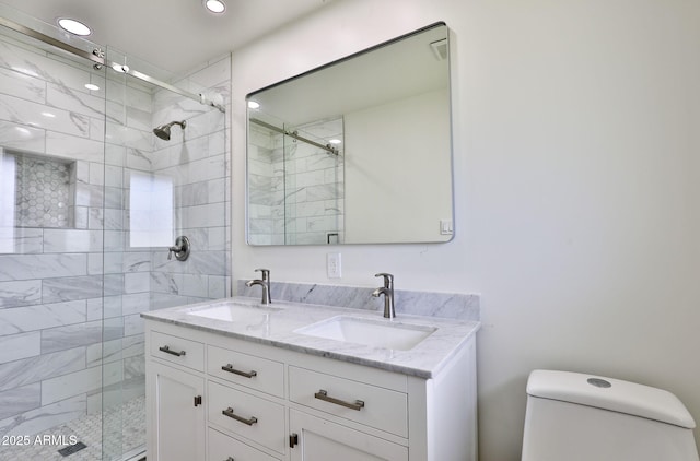 bathroom with vanity, toilet, and a shower with shower door