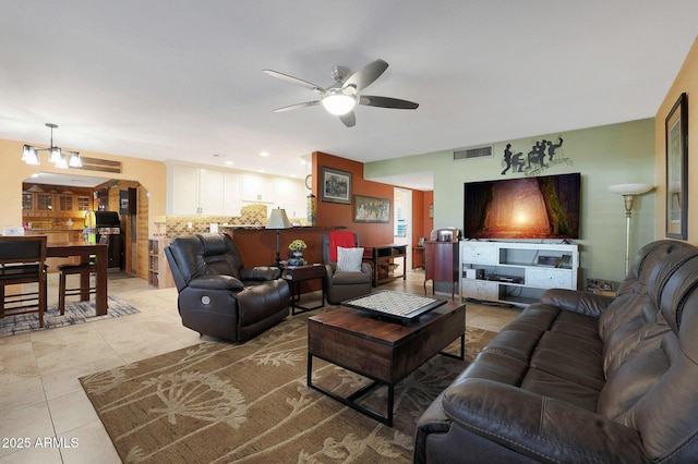 living room with light tile patterned floors and ceiling fan with notable chandelier