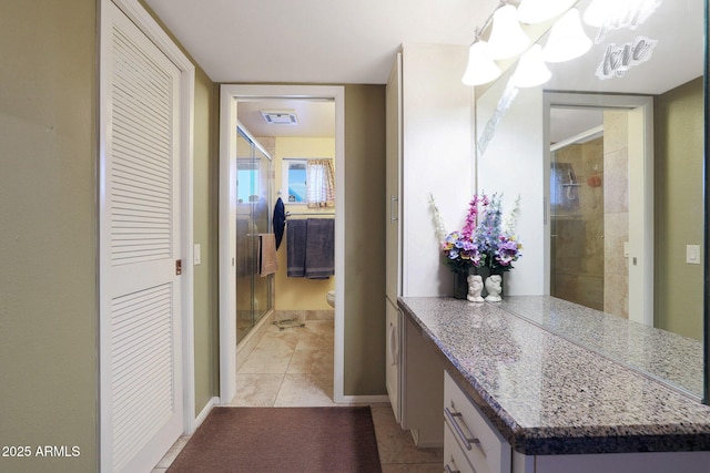 bathroom with a shower with door, tile patterned floors, and an inviting chandelier