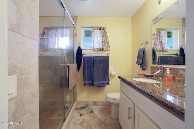 bathroom featuring tile patterned floors, toilet, vanity, and an enclosed shower