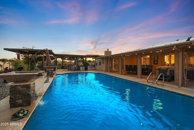 pool at dusk featuring an outdoor bar and a patio area