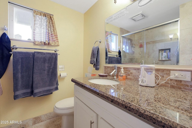 bathroom with tile patterned floors, a shower with door, vanity, decorative backsplash, and toilet