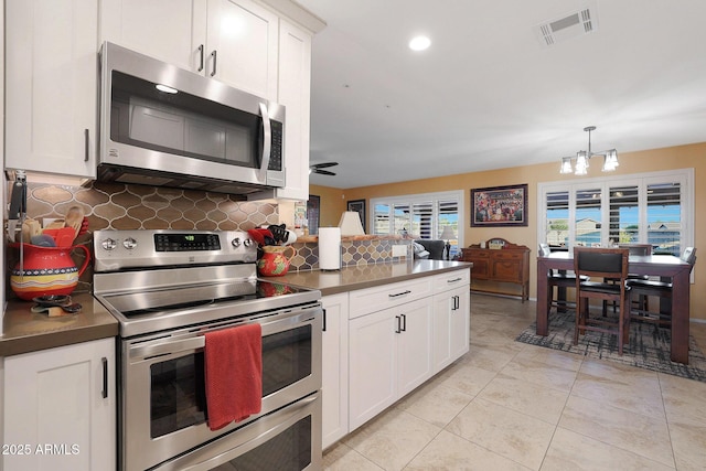 kitchen with decorative light fixtures, white cabinets, appliances with stainless steel finishes, and ceiling fan with notable chandelier