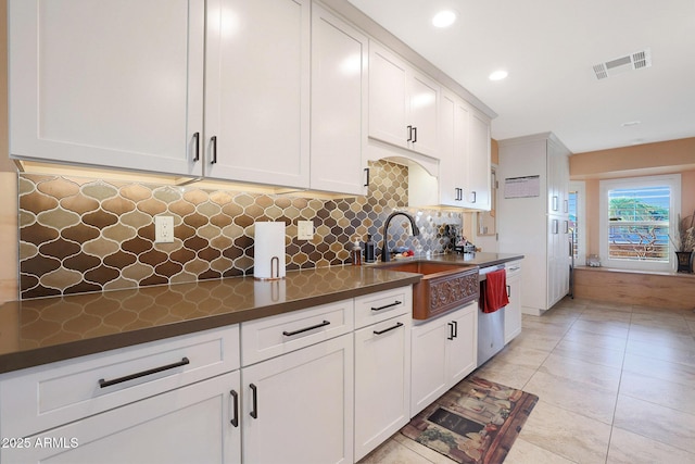 kitchen featuring white cabinets, dishwasher, and sink