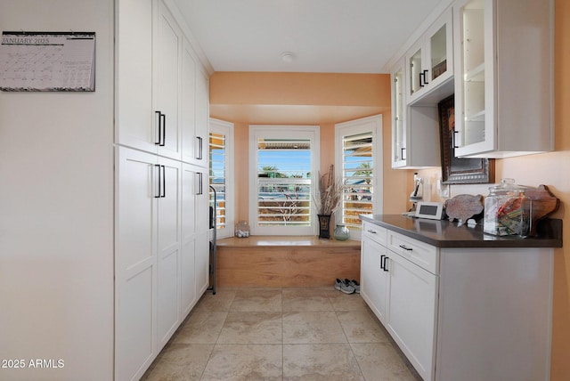 kitchen with light tile patterned floors and white cabinetry