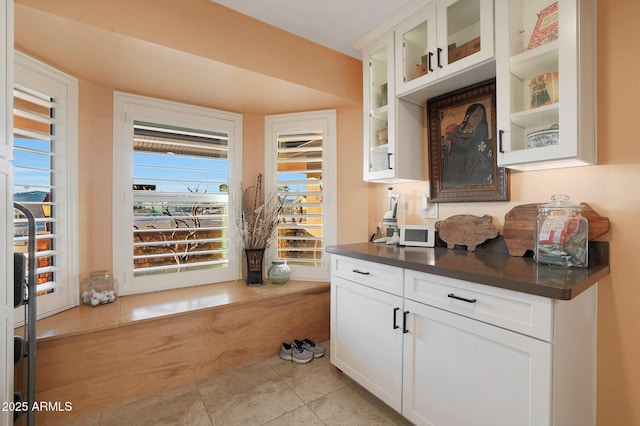 interior space with light tile patterned floors and white cabinets