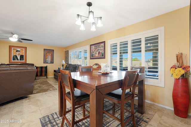 dining area featuring light tile patterned floors and ceiling fan with notable chandelier