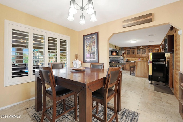 tiled dining space featuring a notable chandelier